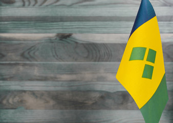 Fragment of the flag of Saint Vincent and the Grenadines in the foreground blurred light background...