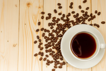 cup of coffee and beans on wooden background