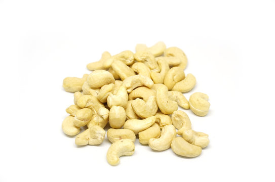 Cashew nuts heap on white background in macro shot.
