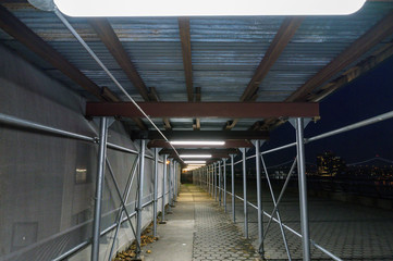 Walkway underneath a scaffolding on Manhattan's Upper East Side at night, New York City