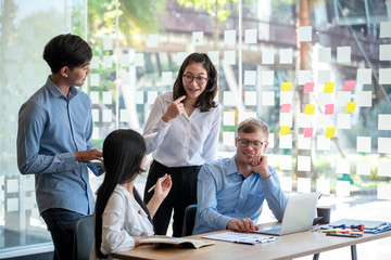 Group of young asian business people together share opinions and propose new marketing and business ideas at meeting.