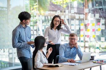 Group of young asian business people together share opinions and propose new marketing and business ideas at meeting.