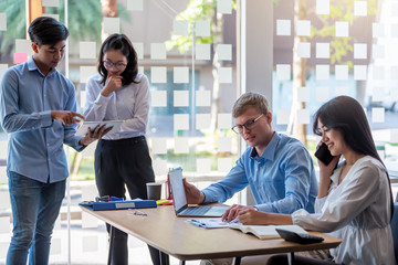 Group of young asian business people together share opinions and propose new marketing and business ideas at meeting.