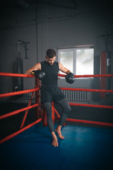 In a boxing ring athletic man have a break time after a boxing workout , he are brutal and very concentrated