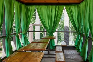 Wooden gazebo standing in green garden in a summer day