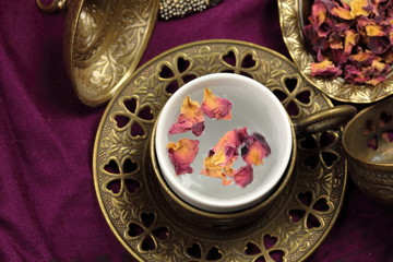 A tea cup of Rose tea with rose petals