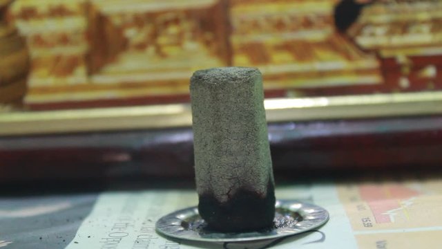 Close up shot of dhoop batti / incense stick burning with some smoke on the pooja room