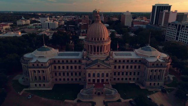 Aerial sunset shot center framed from a close-up of the eagle on top to a super high wide of the Mississippi State Capitol building in Jackson MS