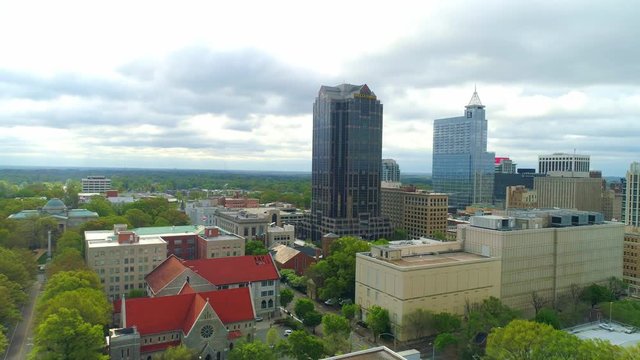High aerial flight pulling back from downtown Raleigh North Carolina on an overcast day
