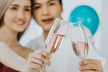 Young couple celebrating new year together, selective focus at cocktail glasses.
