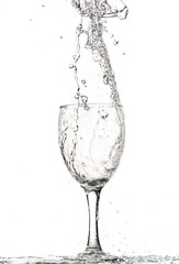 fast flow of wine in a glass, splash and spray black and white