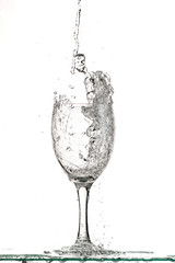 fast flow of wine in a glass, splash and spray black and white