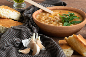 Served traditional hot beans soup with corn bread, garlic and olive oil. Vegetarian healthy dish, vegan food