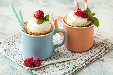 Homemade  vanilla ice cream with fresh mint in color cup. Sweet berry summer dessert. concrete background copy space