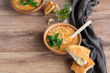 Served traditional hot beans soup with corn bread, garlic and olive oil. Vegetarian healthy dish,...