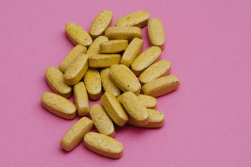 vitamins and minerals in tablets for athletes on a pink background. Sports and healthy nutrition.