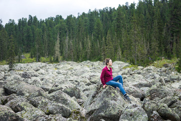 a girl on the background of nature, sitting on a mountain