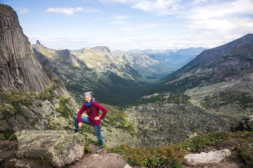 Fototapeta na wymiar a girl on the background of nature, sitting on a mountain
