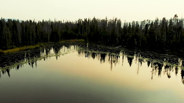 Aerial drone shot of Alexander Lake in Utah's Uinta Mountain Range just east of Kamas. Shot includes family of ducks and two fisherman on paddle boards on the lake at sunset.