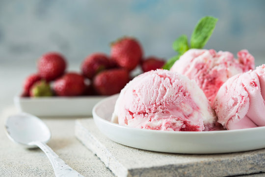 Homemade strawberry vanilla ice cream with fresh strawberries. Sweet berry summer dessert. Concrete  background copy space