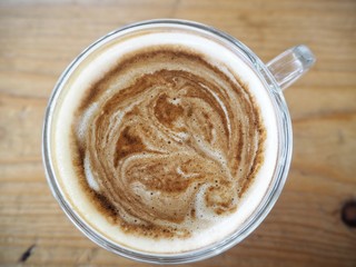 Hot coffee with milk on wood background