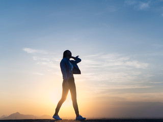Free young woman slim body walking at golden sunset. Freedom and success concept,relaxing and enjoying a sunny summer holiday.