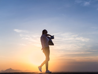 Free young woman slim body walking at golden sunset. Freedom and success concept,relaxing and enjoying a sunny summer holiday.
