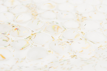 White soft light texture of heap transparent balls with golden glitter as elegant modern holiday abstract background.