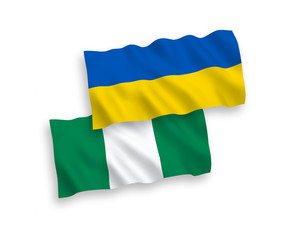 National vector fabric wave flags of Nigeria and Ukraine isolated on white background. 1 to 2 proportion.
