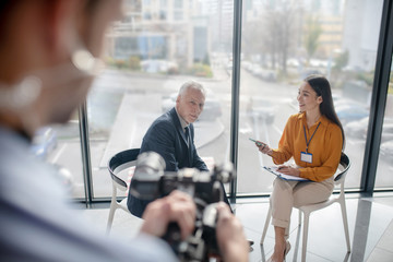 Asian female reporter with long hair interviewing a famous businessman