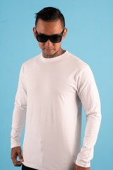 A man wearing white t shirt isolated on background. Hipster man with tattoo and sunglasses wearing white long sleeve t shirt ready for your mock up template or background.