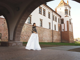 Obraz premium A young woman walks around an old manor, a castle, a beautiful park. Tourism, sightseeing. Traveling in Belarus. The surroundings of Minsk.