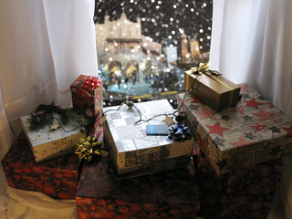 Christmas scene with gifts near window in room overlooking night city