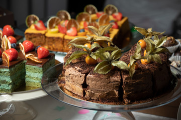 Sliced tasty chocolate cake in plate on table, closeup