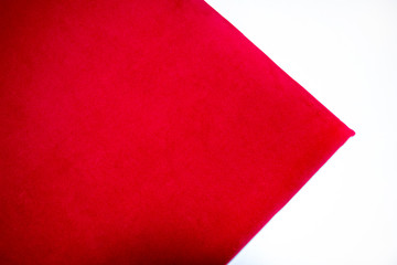 Close-up of red color velvet texture on a white background. Top view.