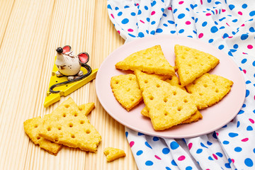 Funny kids cookies. Festive cheese crackers, New Year snack concept. Food, mouse sculpture, napkin. Wooden planks background
