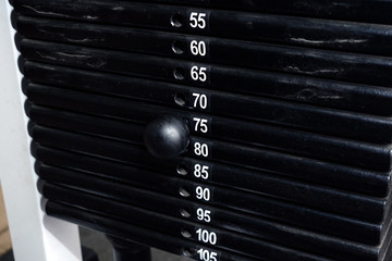 Seventy-five kilos weight set on a training machine. Pullover strength training equipment. Overall...