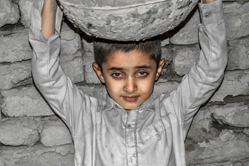 a very young orphan child is forced into child labor and working at a construction site and his...