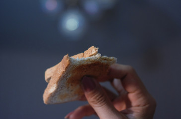 Woman holding a toasted bread with bite marks