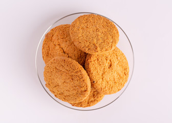 Oatmeal cookies top view. Oatmeal cookies in a glass plate on a white background.
