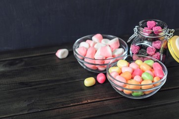 multi-colored candies in a plate, bank and bowls with copy space - 307581046