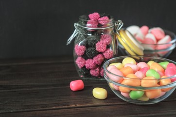 multi-colored candies in a plate, bank and bowls with copy space - 307581071