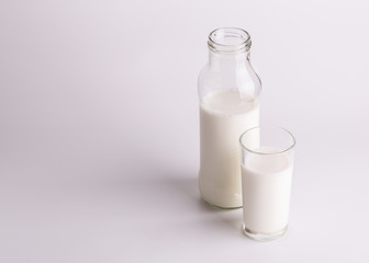 An open bottle of fresh milk. Glass and bottle with milk close-up.