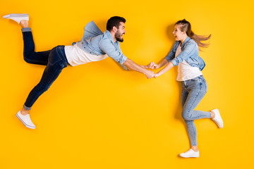 Fototapeta na wymiar Top view above high angle flat lay flatlay lie full length body size view concept of cheerful crazy beautiful handsome people having fun isolated on bright vivid shine vibrant yellow color background
