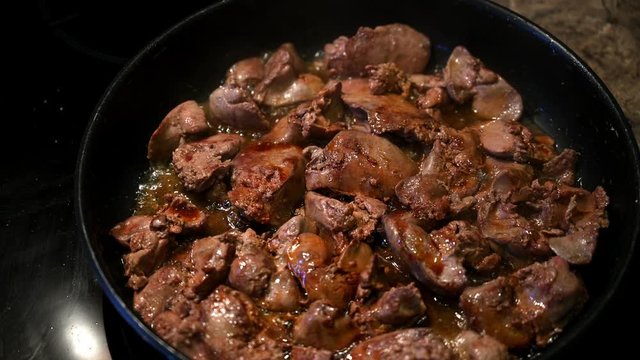 Homemade chicken liver is fried in a frying pan and watered with soy sauce