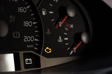 Fototapeta Yellow lit engine error sign on car dashboard close up obraz