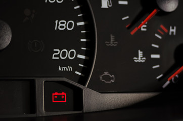 Close up shot of a car's dashboard with the battery icon lit.