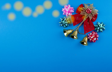 blue background decorated with ribbon bow, ornament, golden bell