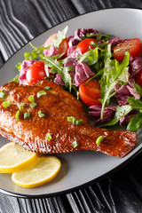 Fried Sebastes served with fresh vegetable salad close-up in a plate. vertical