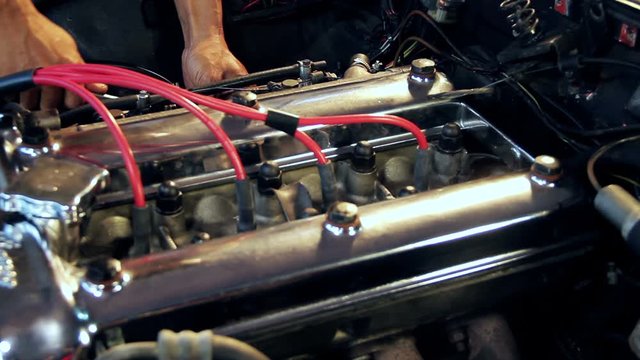 Auto mechanic doing repairs on engine from a classic car